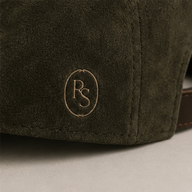 Close-up of the embroidered RS crest on the olive suede Rich and Stressed cap
