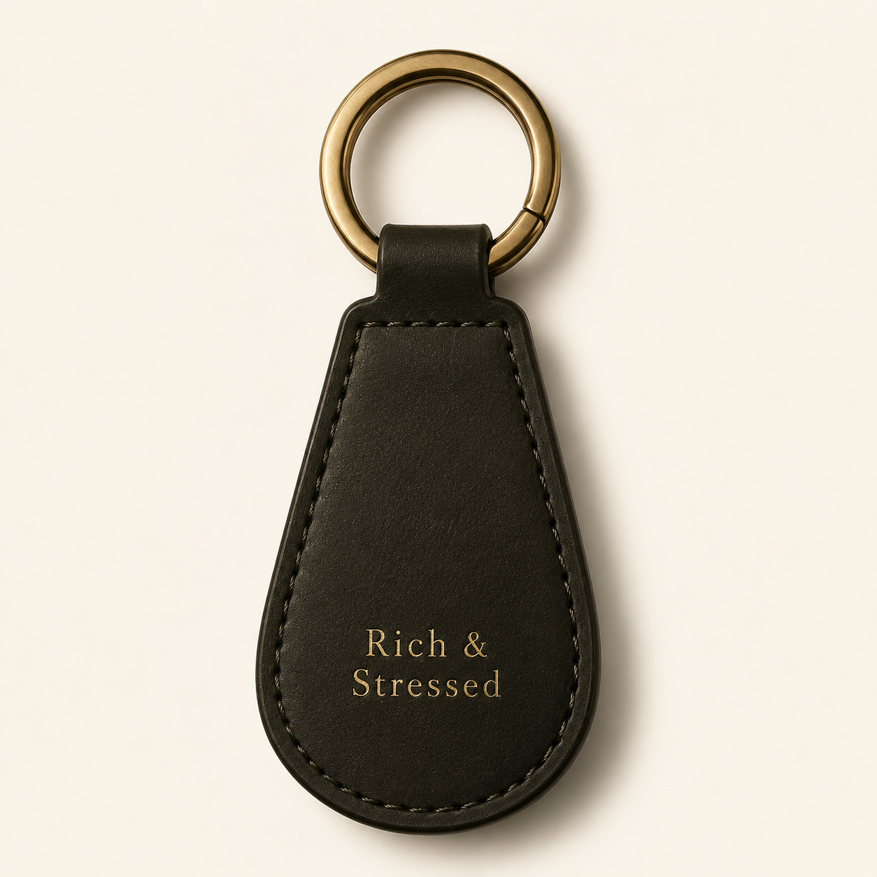 Black leather Rich and Stressed key fob with gold embossed serif lettering and brass ring
