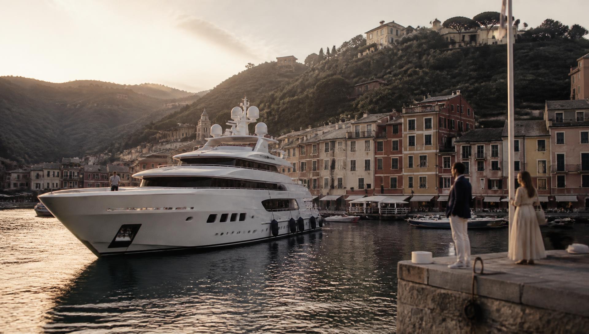 A yacht arriving in Portofino harbour at golden hour